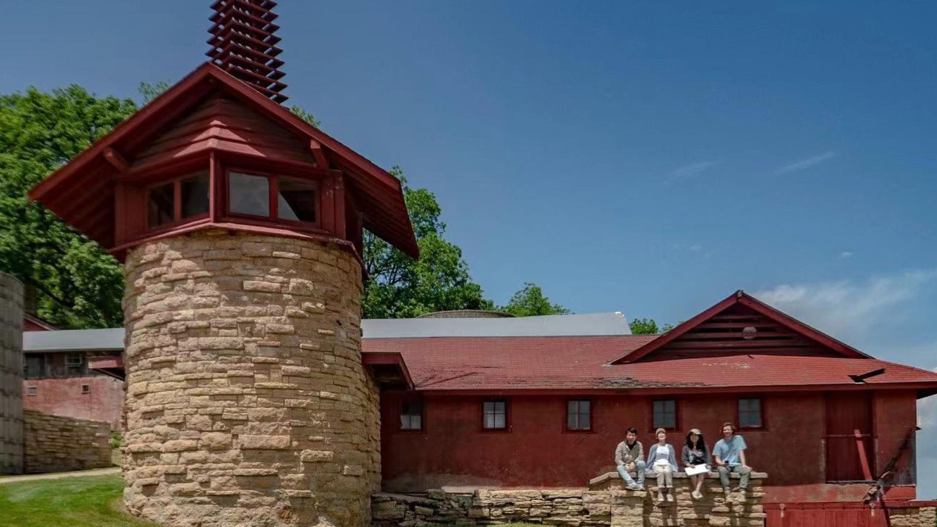 Barn connected to stone tower with steeple and weather vane