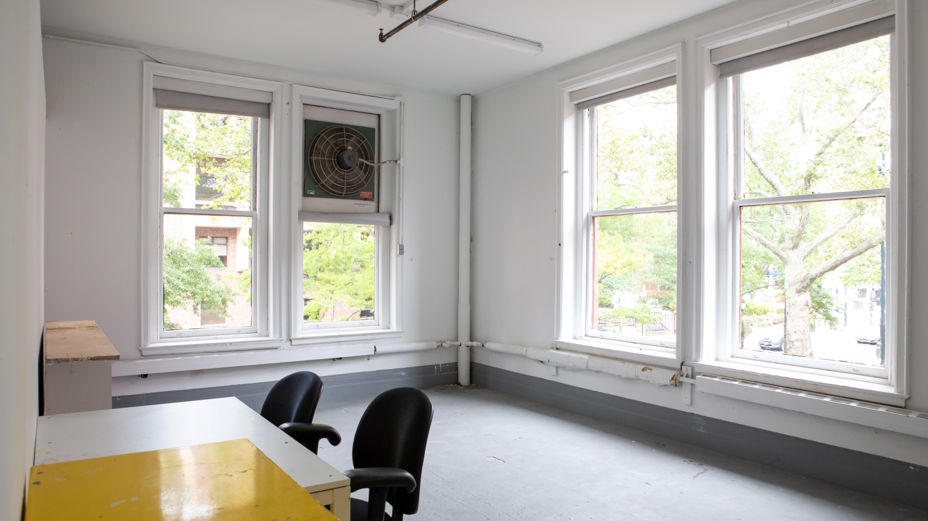 empty corner studio with chairs and four windows