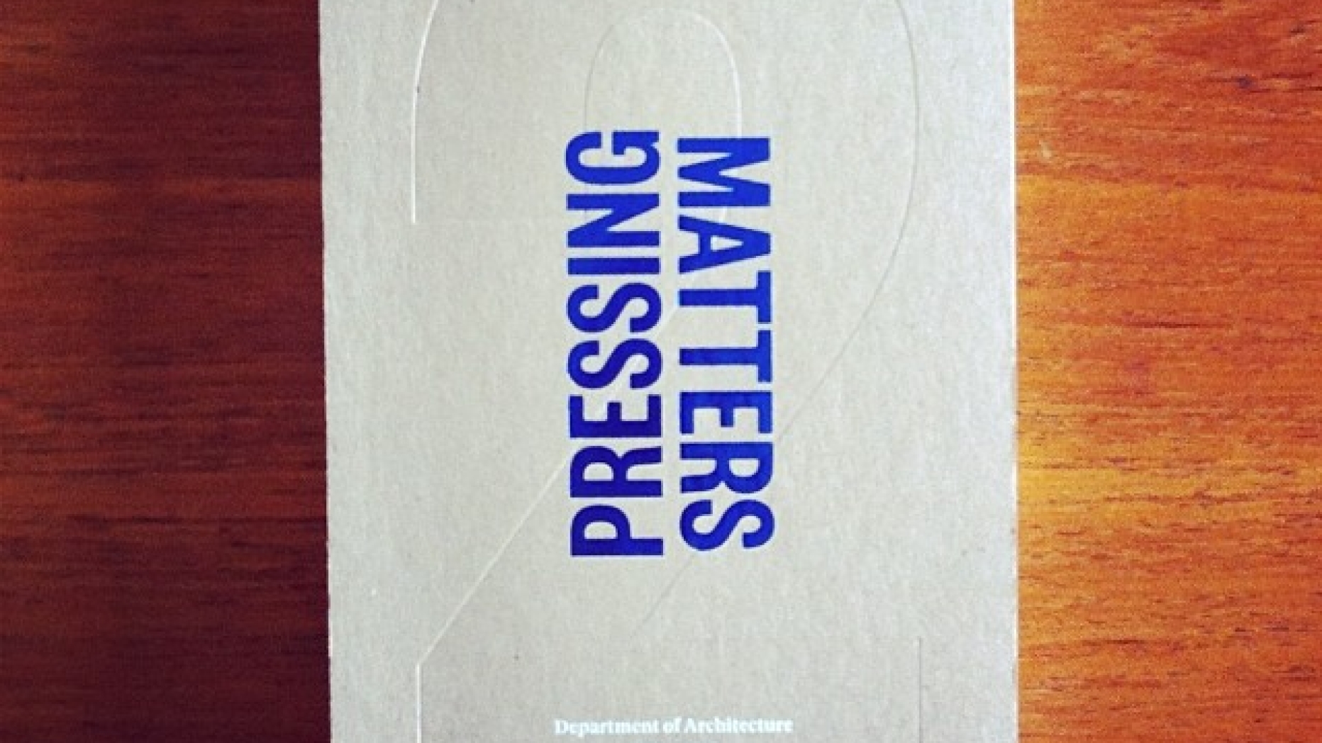 Copy of book, "Pressing Matters 2" sitting on wooden table.