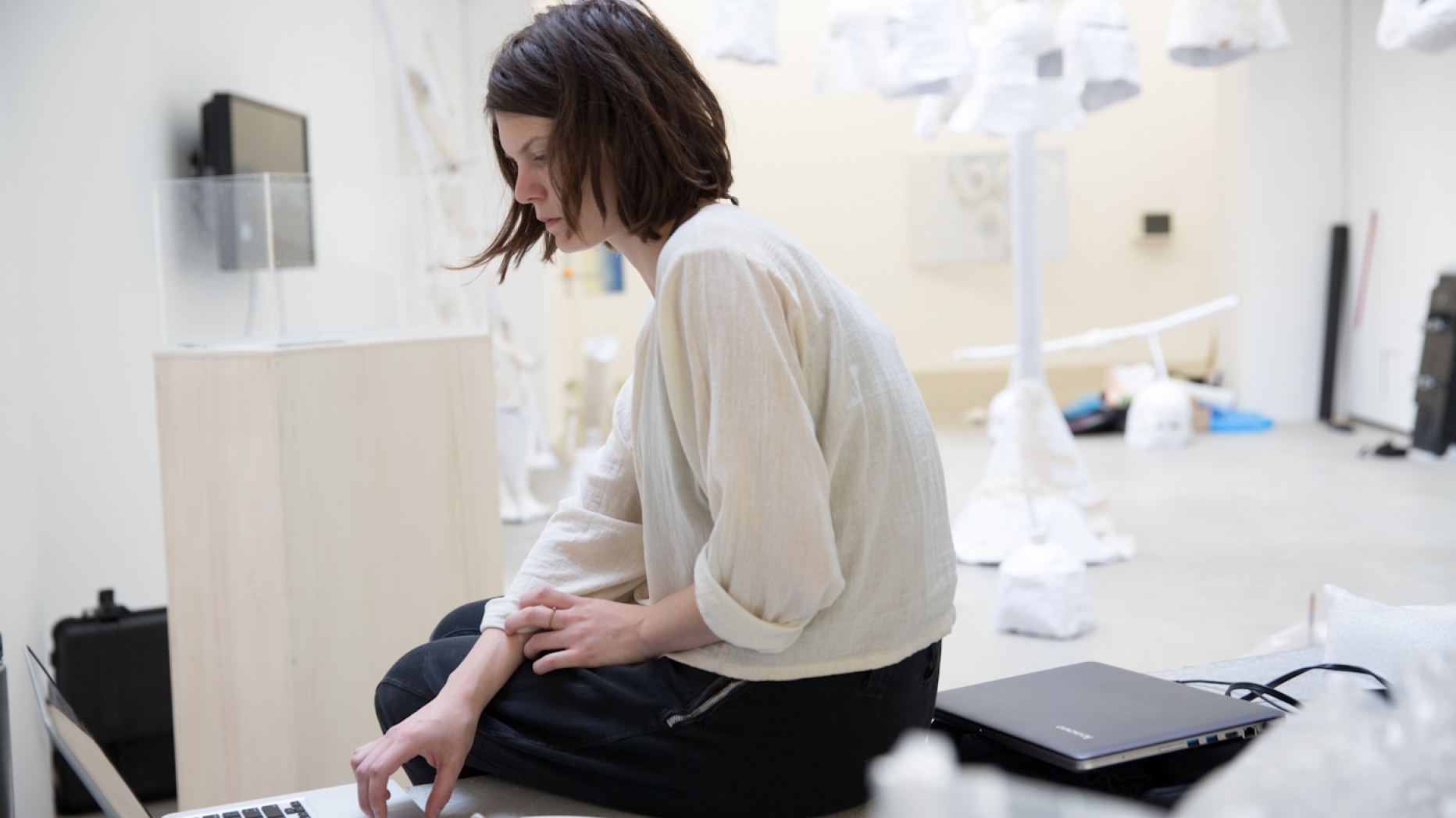 Student working at computer in gallery space.