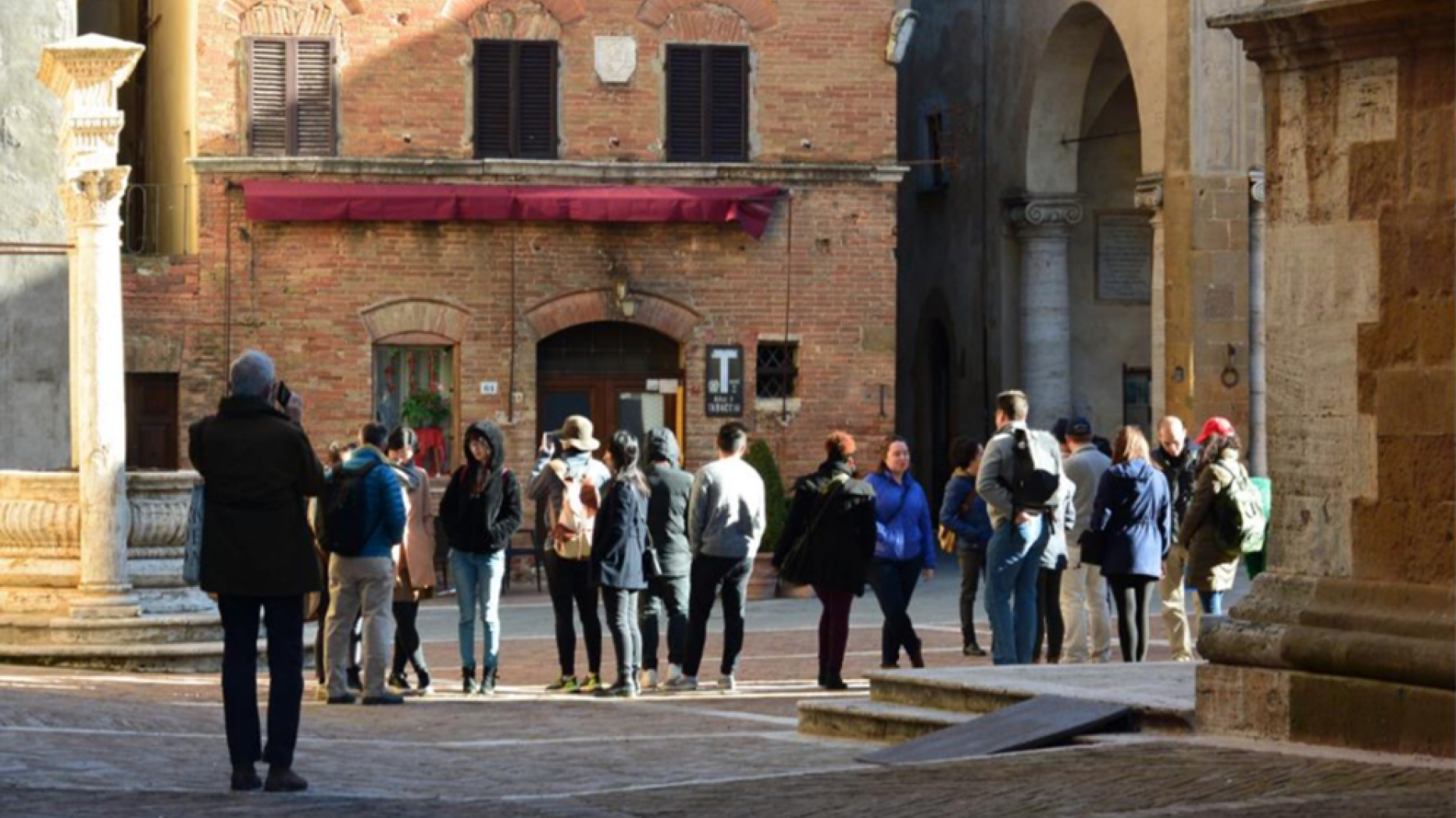 Tourists walking in old Italian city.