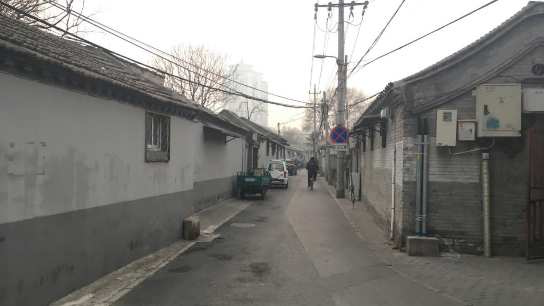 White and gray one-story buildings line a narrow alley way