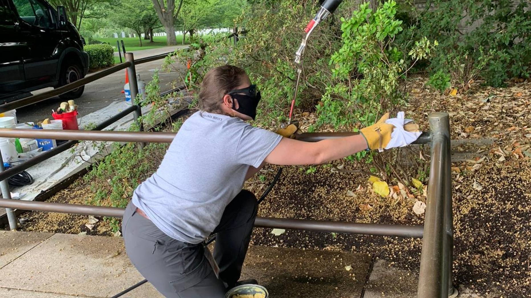 Jennifer Boggs applies hot wax to the bronze railings at Arlington National Cemetery.