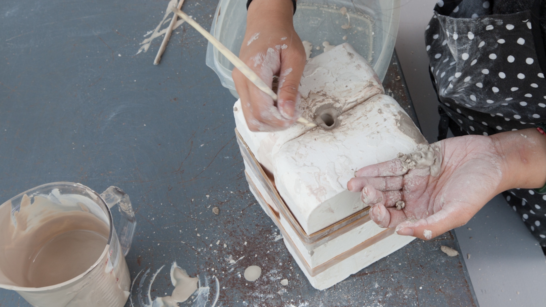 Close up of student working with clay using a press mold.