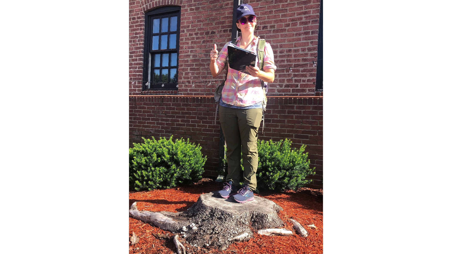 Haoyi's supervisor, Meg Frisbie, is using the arrow to record the location of the tree stump as part of the data collection proc