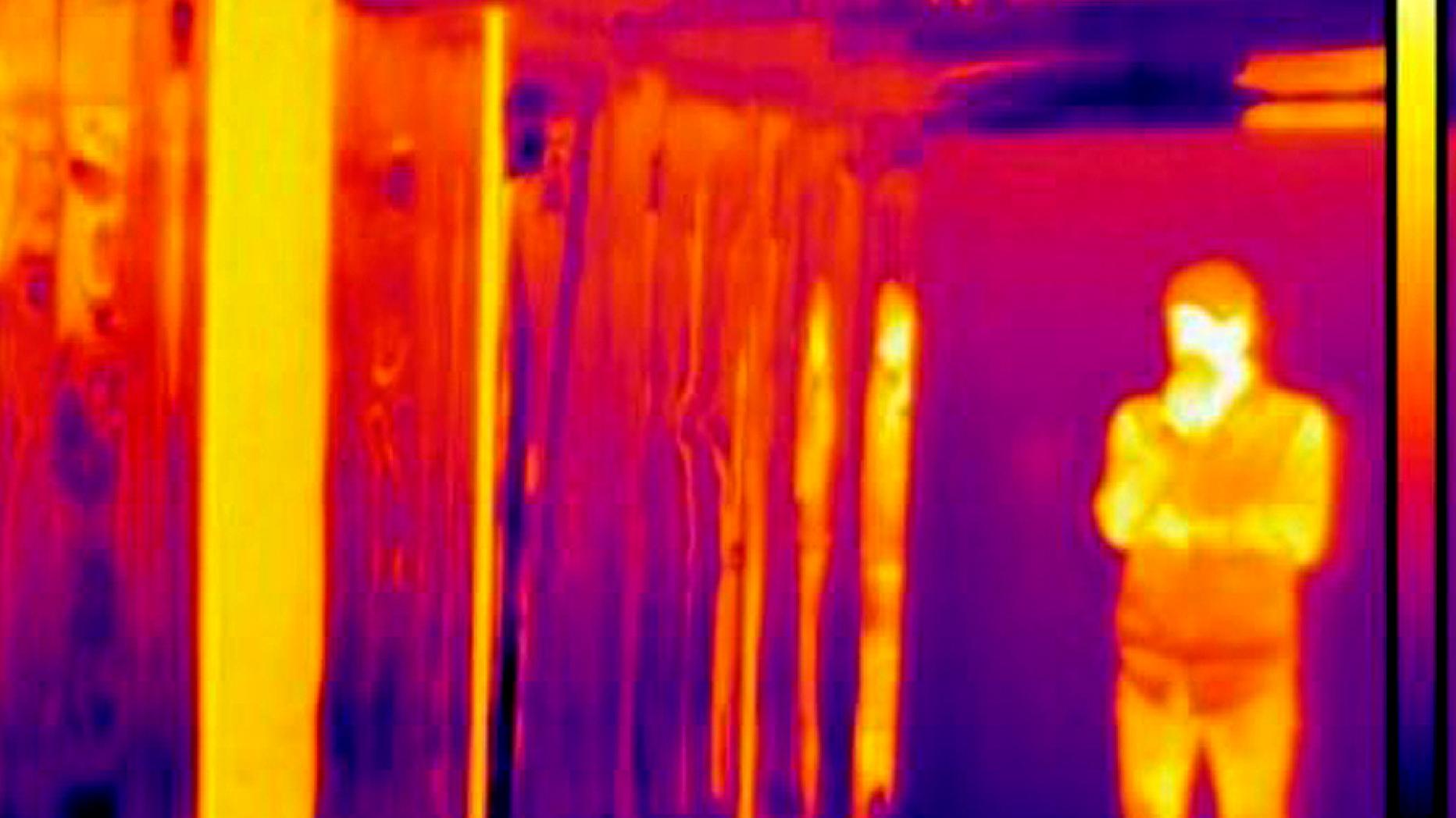 Infrared photograph of a person standing surrounded by hot and cold surfaces