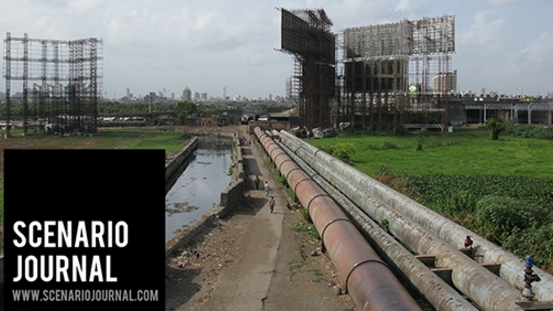 Pipeline along a canal in a grassy field