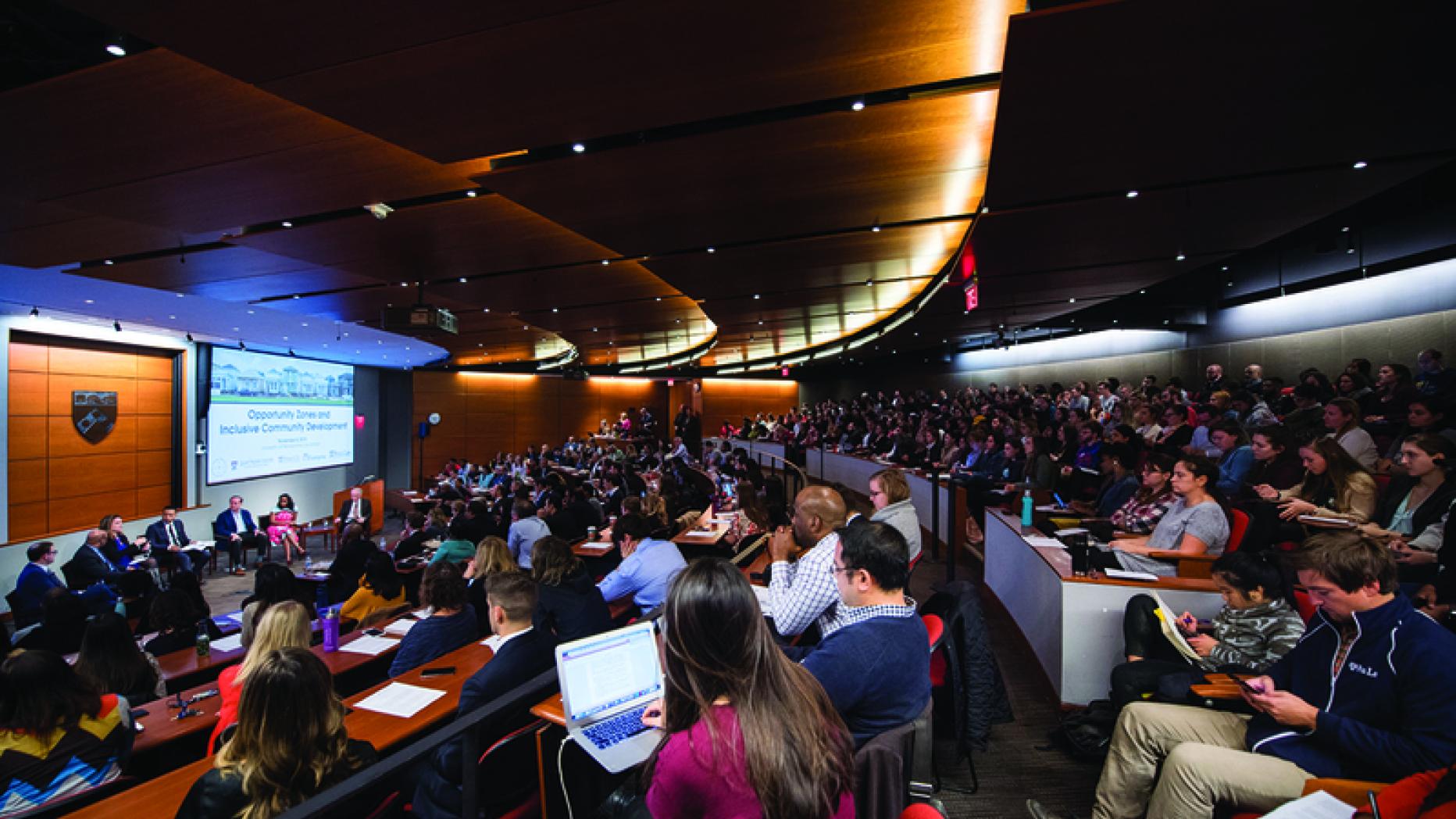 A large group of people watching a conference