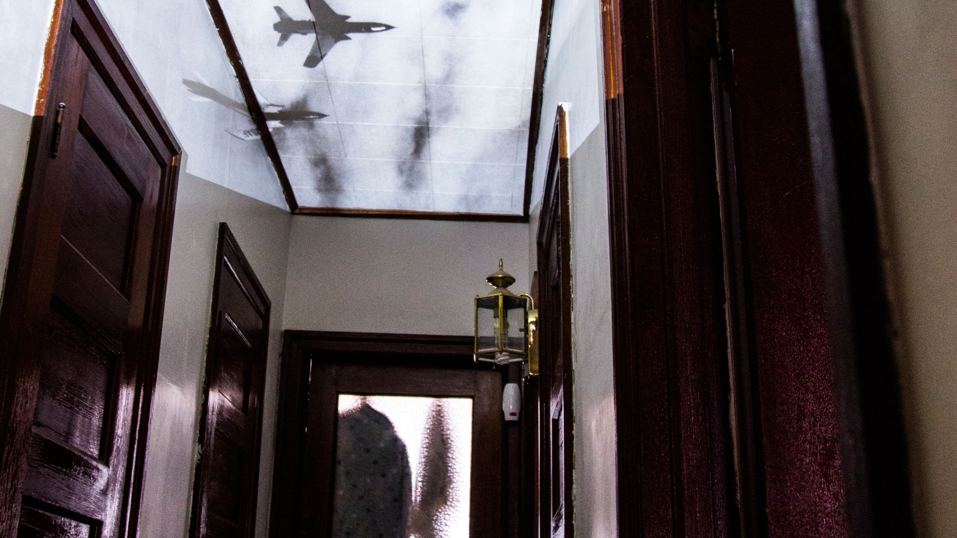 Hallway with images of bomber planes projected on to the ceiling.
