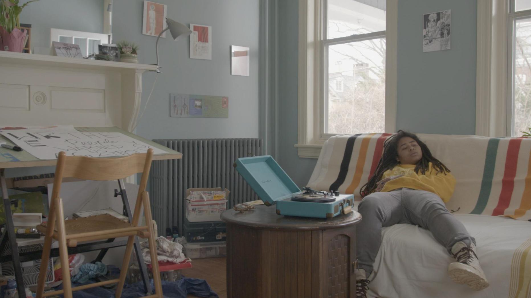 Child sleeping on couch with record player on table