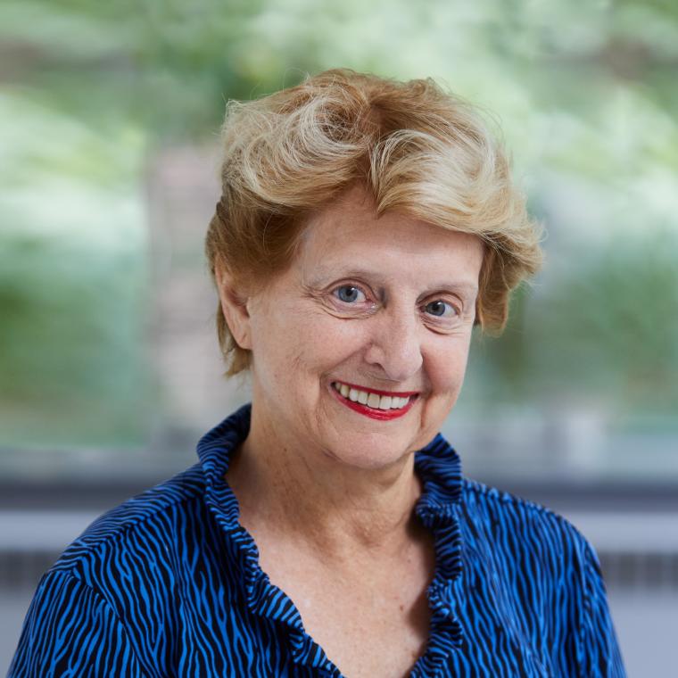 Headshot of Genie Birch wearing a blue dress