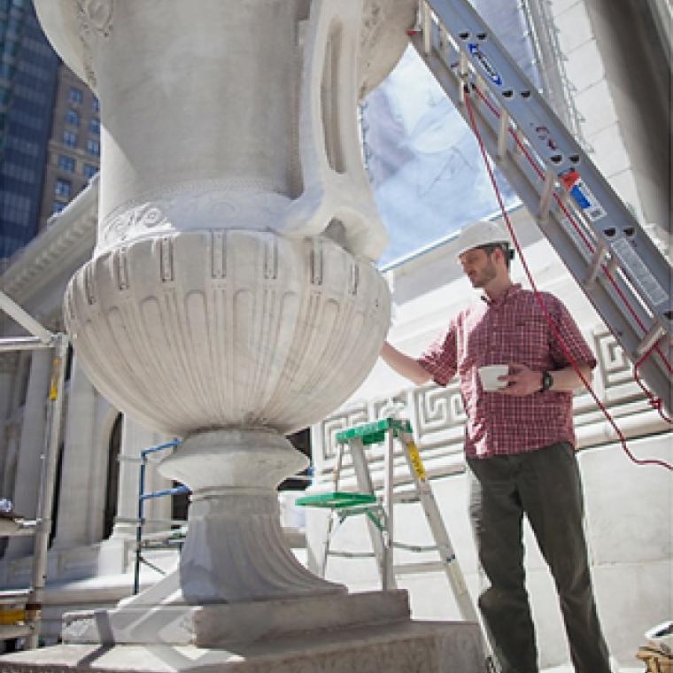 person working on large vase in the foreground