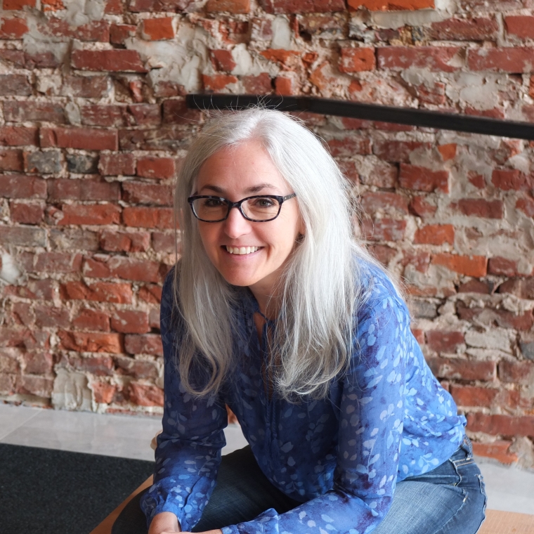 Holly Boyer sitting in front of a brick wall