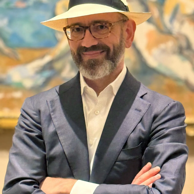 Photograph of Carlos Basualdo in front of a painting