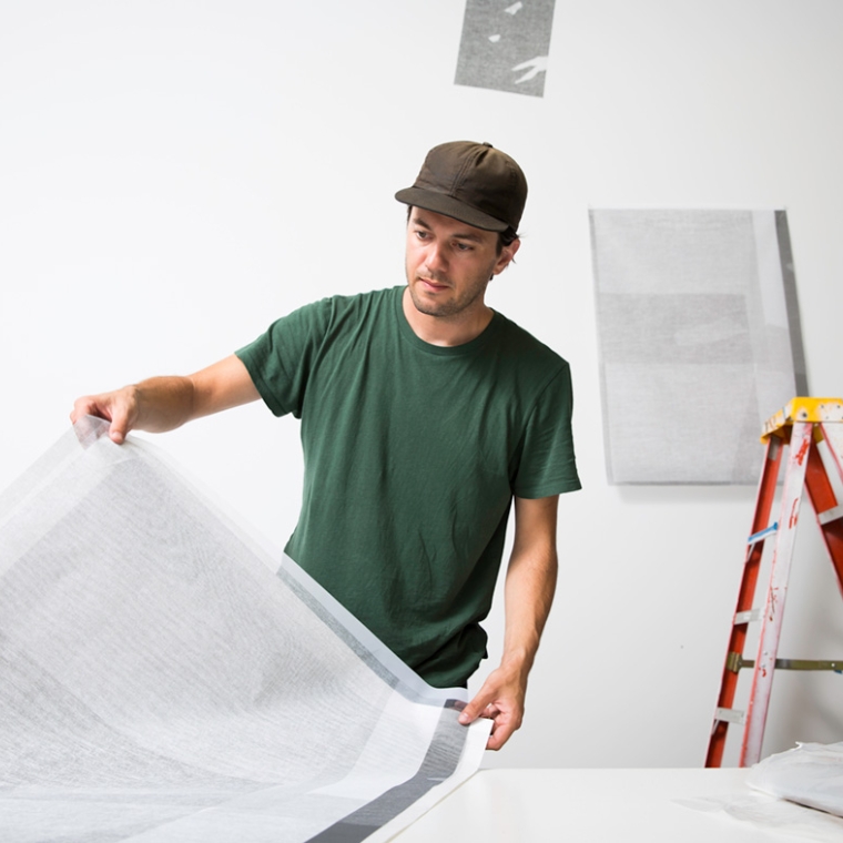 Photograph of Micah Danges examining a print