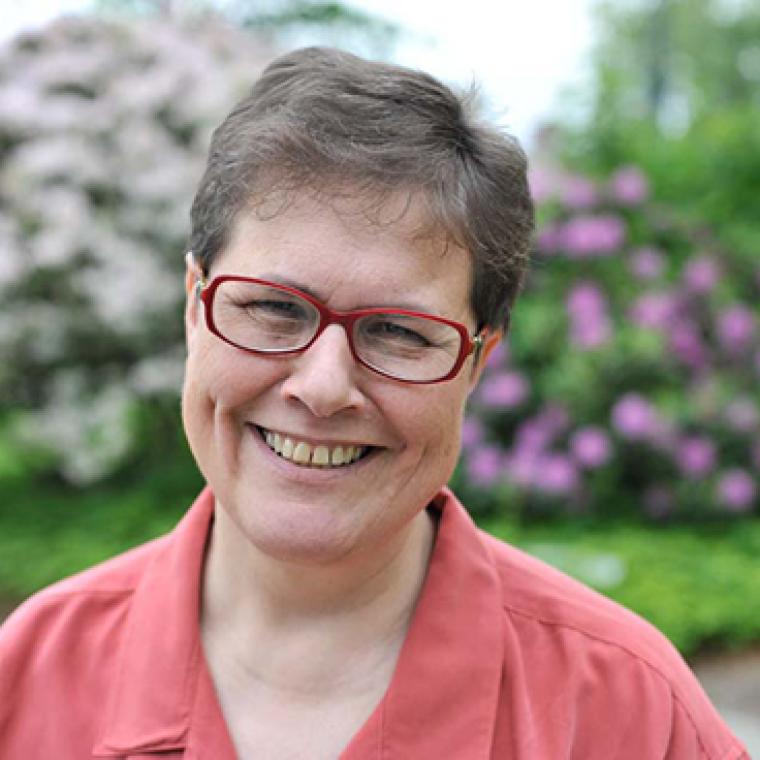 Woman headshot in front of flowers 