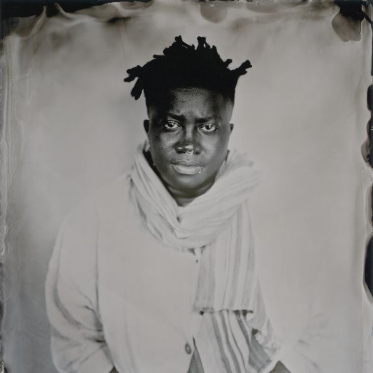 tintype image of TNM sitting making direct eye contact with camera