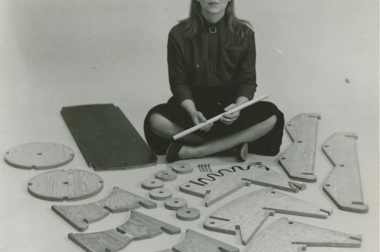 Anne Griswold Tyng sitting on floor surrounded by wooden cutouts
