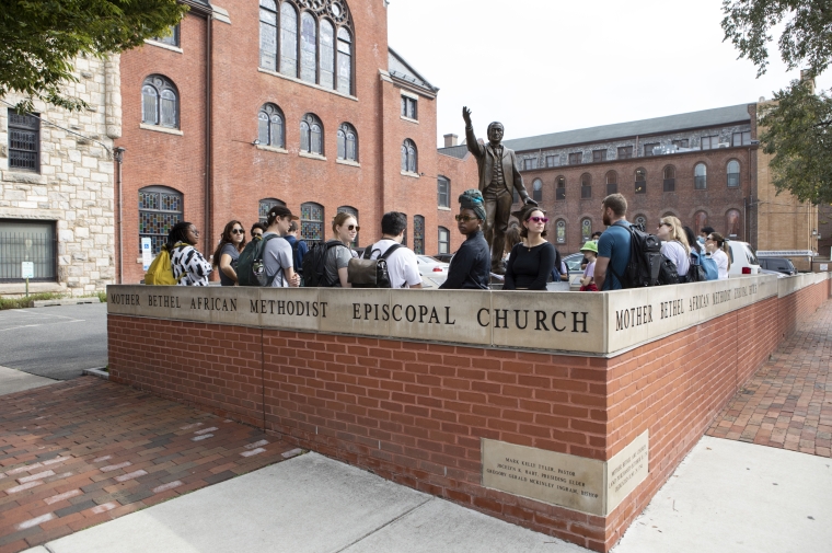 group of students stand by statue at Mother Bethel AME Church