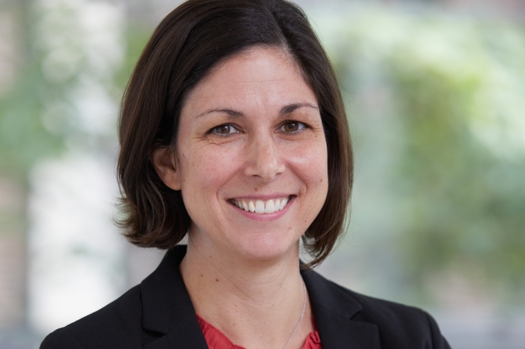 Headshot of Elizabeth Delmelle wearing a dark jacket and red shirt
