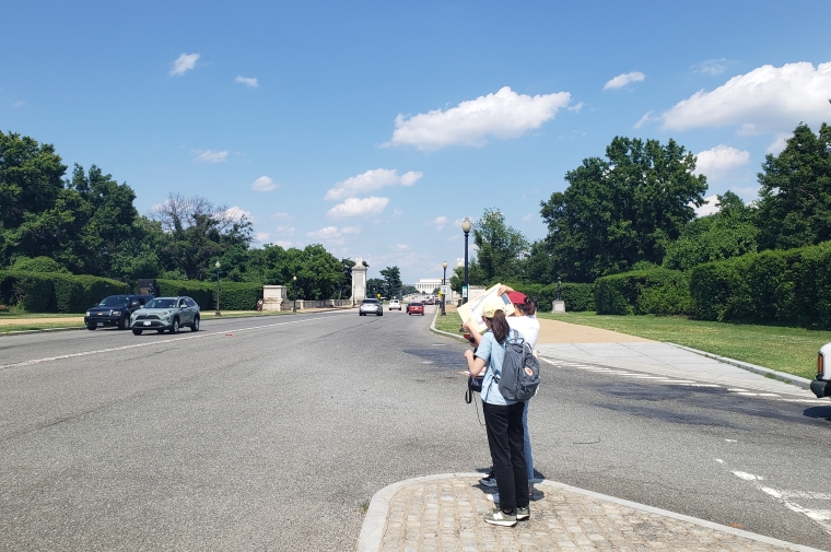 interns on wide corridor with Lincoln memorial visible in distance