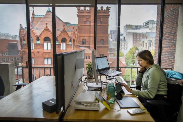 Student working at a desk next to a window