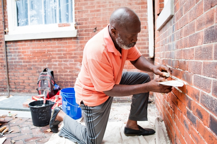 man working on brick wall