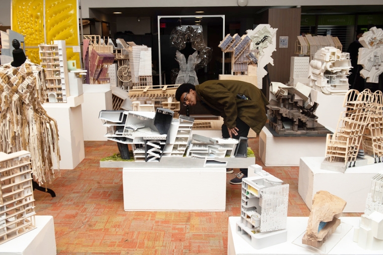 Person crouches next to architectural models