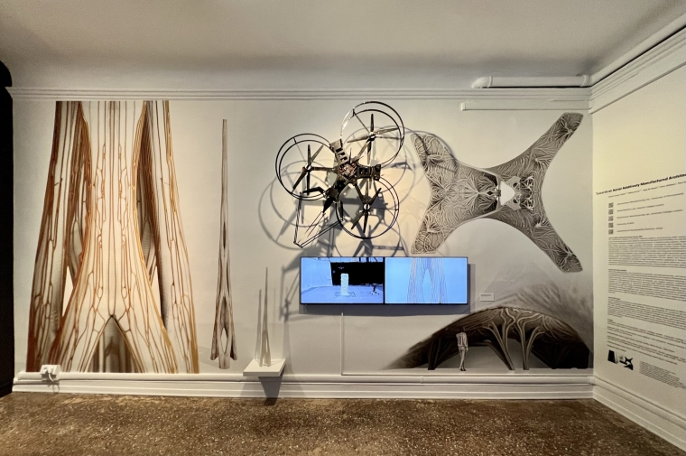 Wall displaying drone above a video monitor on background of large-scale photos