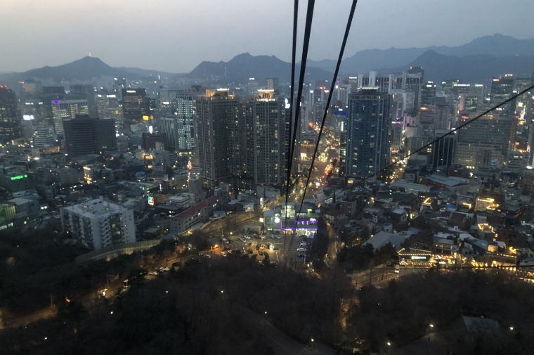 Cable car lines stretch into distance overlooking city at night
