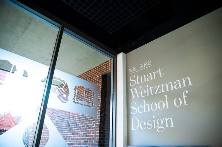 Picture of Stuart Weitzman logo on gray wall inside Meyerson Hall.