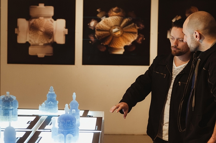 Two students looking at 3D printed models of Baroque buildings.