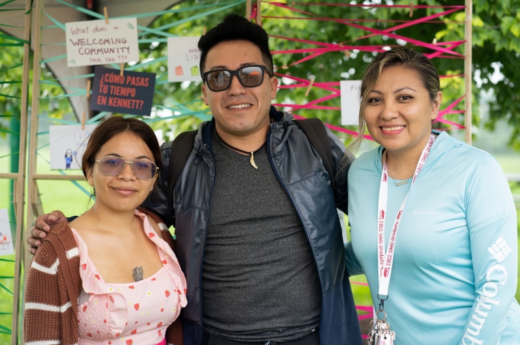 Three people pose for photograph