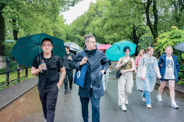 People walk in urban park with umbrellas