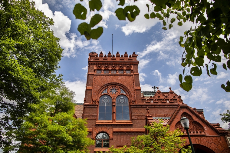Red brick facade against blue sky and trees