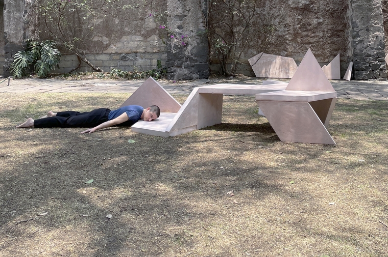 Self portrait of Hall laying face down, resting his head on the edge of his sculpture in a harden