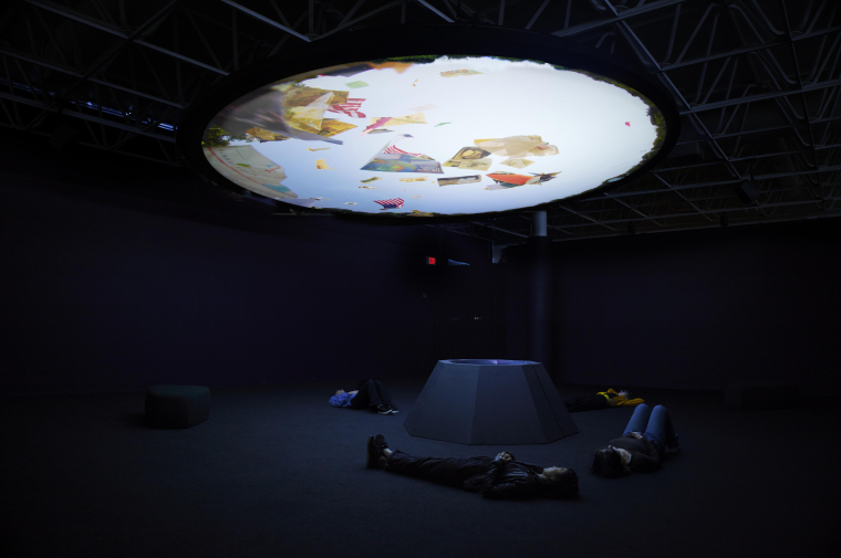 People lying on the floor viewing the ceiling mounted video