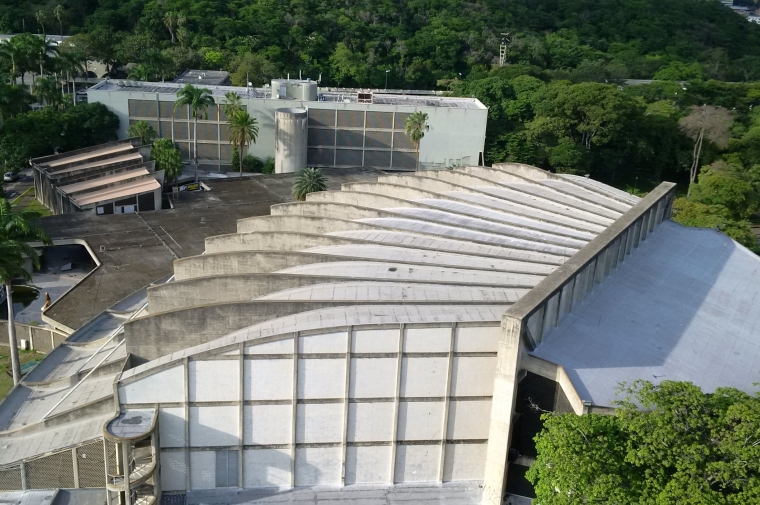 aerial view of concrete sculptural building surrounded by greenery