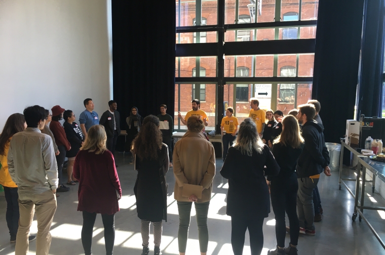 Students participating in "hackathon for good", standing in a circle