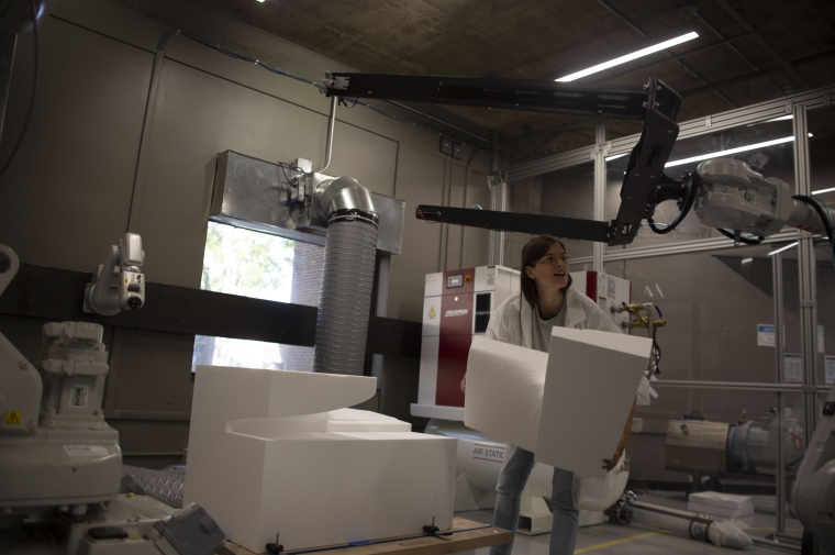 Student holding abstract shape cut by robotic arm