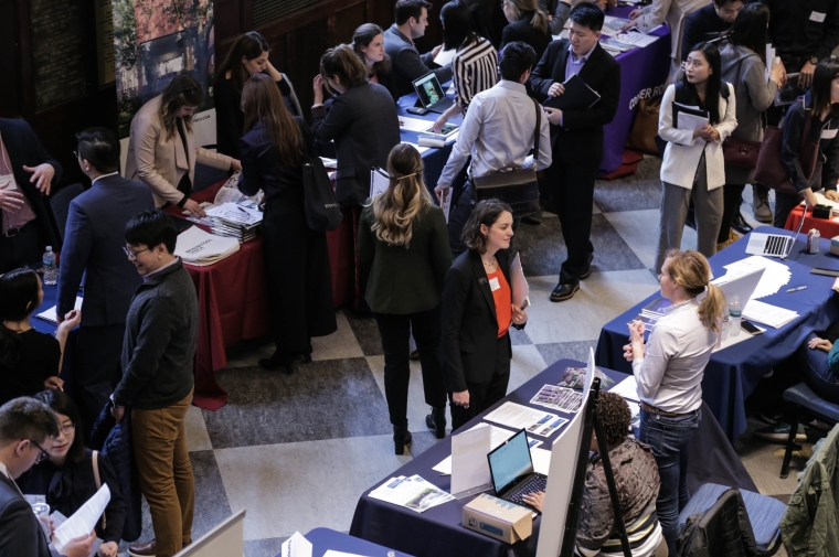 Students waiting in line during a career fair and talking with employers
