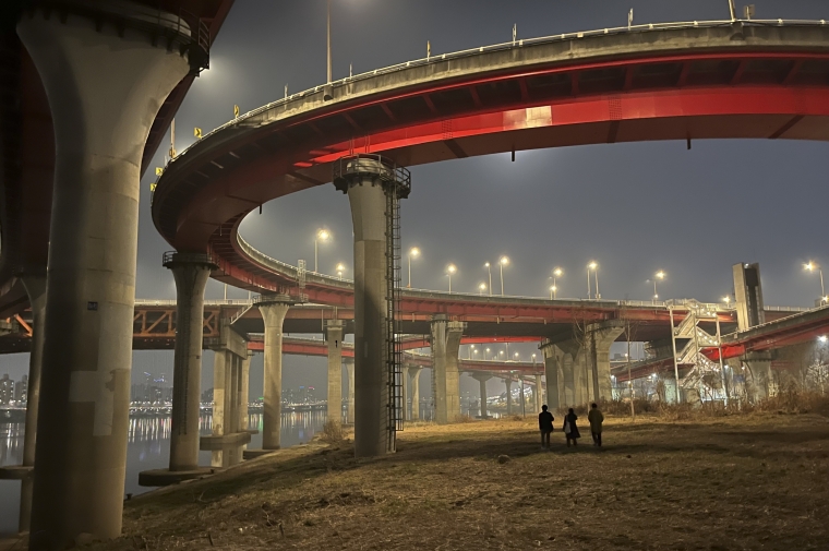 Night view of cement columns and highway adjacent to waterway