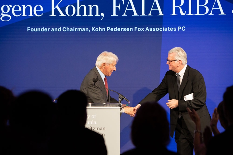 Gene Kohn stands at podium with Fritz Steiner at right