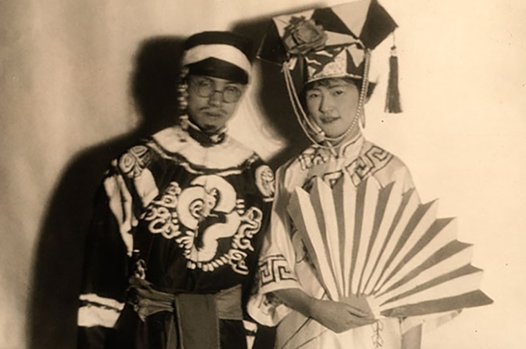 A young Asian couple in costume pose for photo