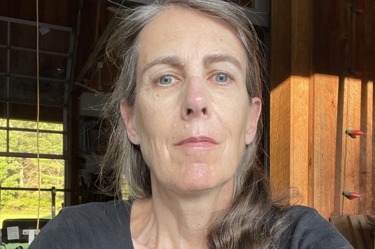 Close-up photograph of Moyra Davey wearing gray teeshirt 