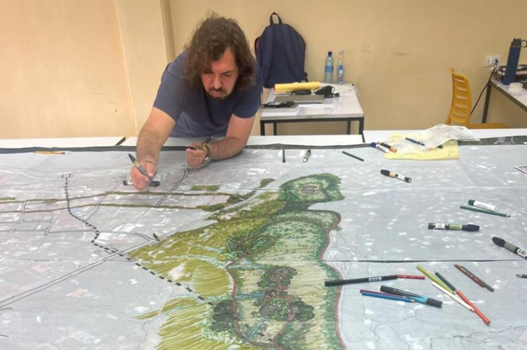 Manuel Contreras works on large-format landscape drawing in front of him