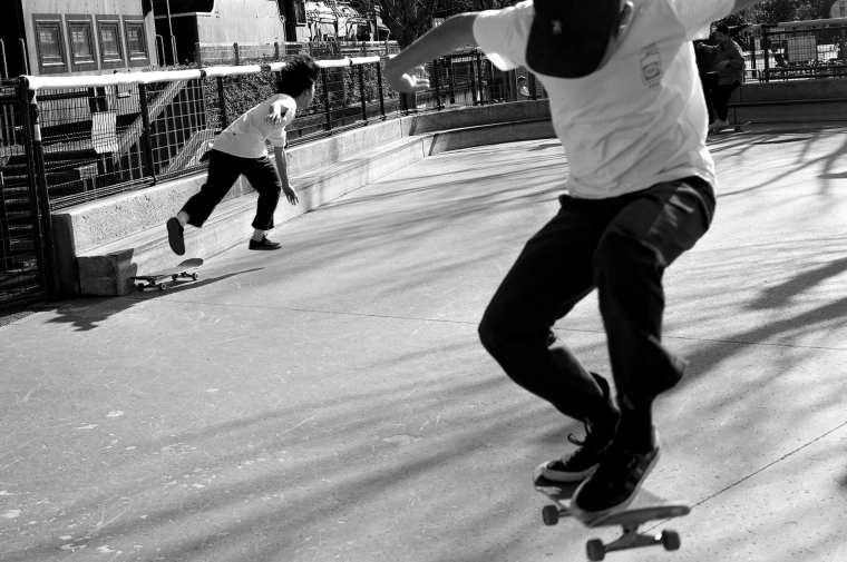 Black and white photograph of skateboarders caught in mid-air