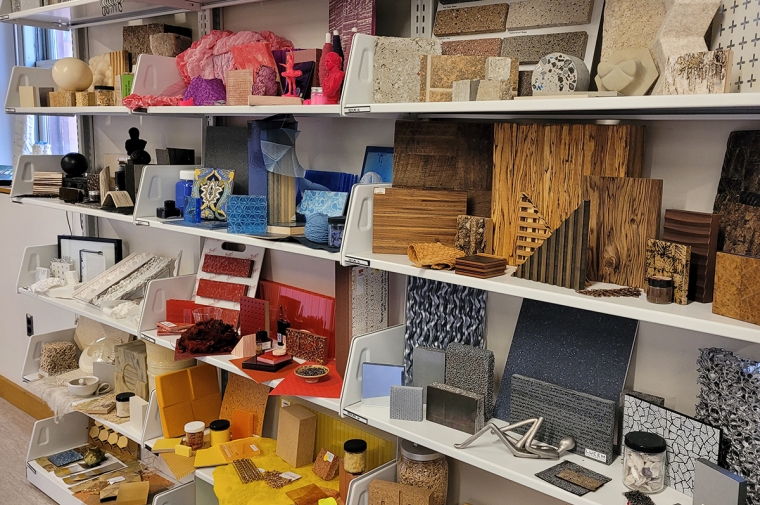 Shelves full of wood and stone tiles, paint jars, and acrylic sheets in a rainbow of colors