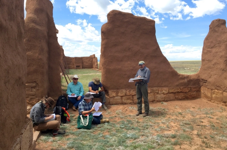 Man stands outdoors in front of earthen wall