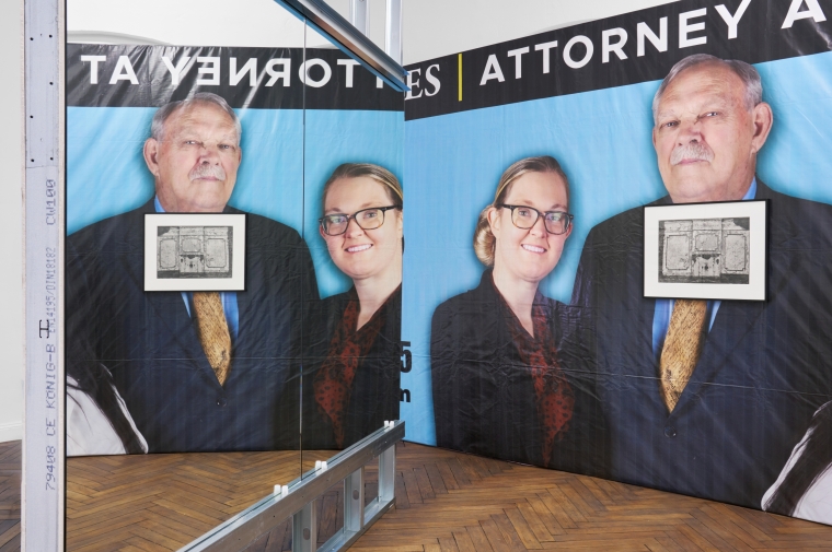 Billboard with four heads behind two framed artworks